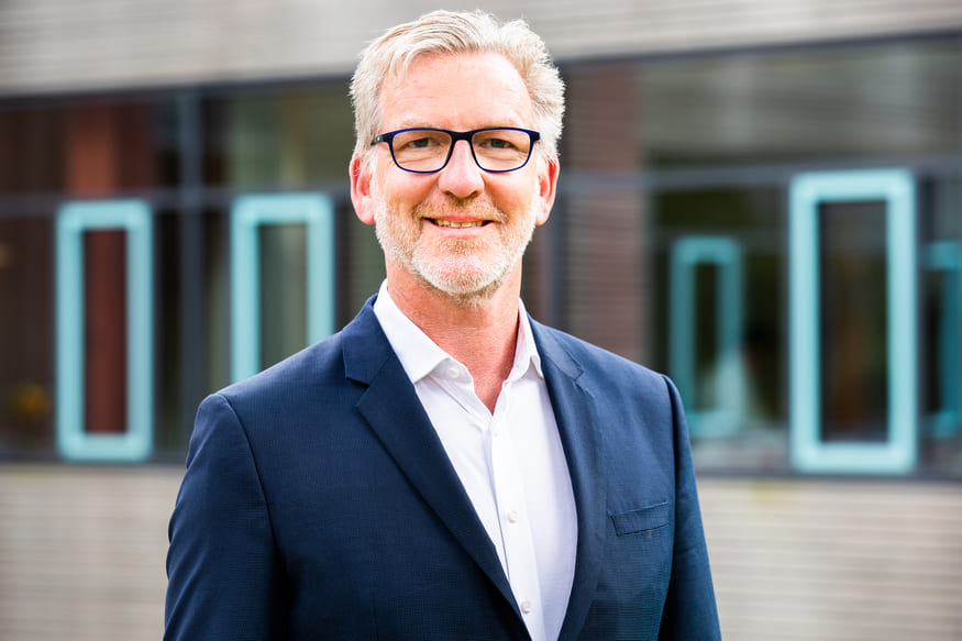 BARMER_KiG_Albrecht Porträtfoto von Matthias Albrecht, einem Mann mit grauem Haar und Brille, der in die Kamera lächelt. Er trägt ein helles Hemd und ein Sakko. Bildnachweis: Lena Sielaff. Matthias Albrecht ist Facharzt für Kinder- und Jugendmedizin und Geschäftsführer bei KLUG, wo er den Aufbau eines Kompetenzzentrums für klimaresiliente Gesundheitseinrichtungen verantwortet. Zuvor leitete er 15 Jahre das Evangelische Krankenhaus Hubertus in Berlin – das erste vom BUND zertifizierte Krankenhaus Deutschlands. Er ist Mitglied der Arbeitsgruppe „Klimawandel