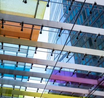 Gesunde Arbeit_Methodik_k Modernes Unternehmensgebäude mit farbiger Glasarchitektur – Symbol für innovative Arbeitswelt